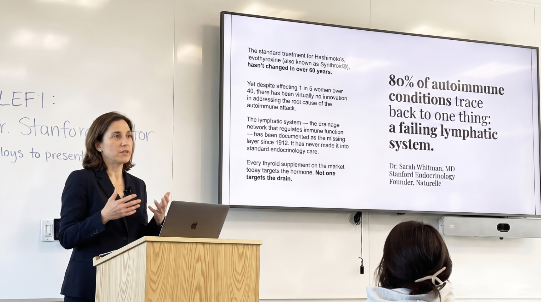 Dr. Sarah Whitman presenting a slide that says 80 percent of autoimmune conditions trace back to a failing lymphatic system